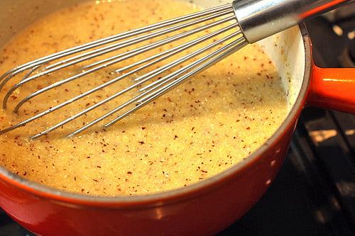 A close-up shot of the polenta batter being poured into a greased baking pan