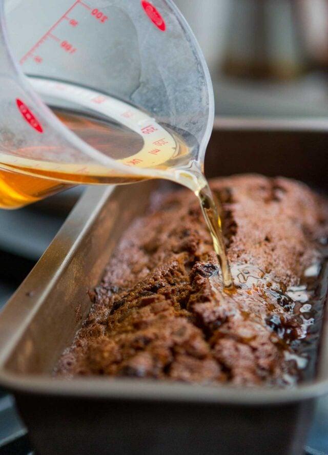A close-up shot of the fruitcake batter being poured into a baking pan