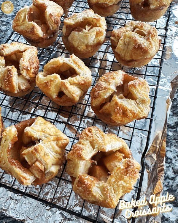 Golden brown apple cinnamon crumble croissants on a baking sheet