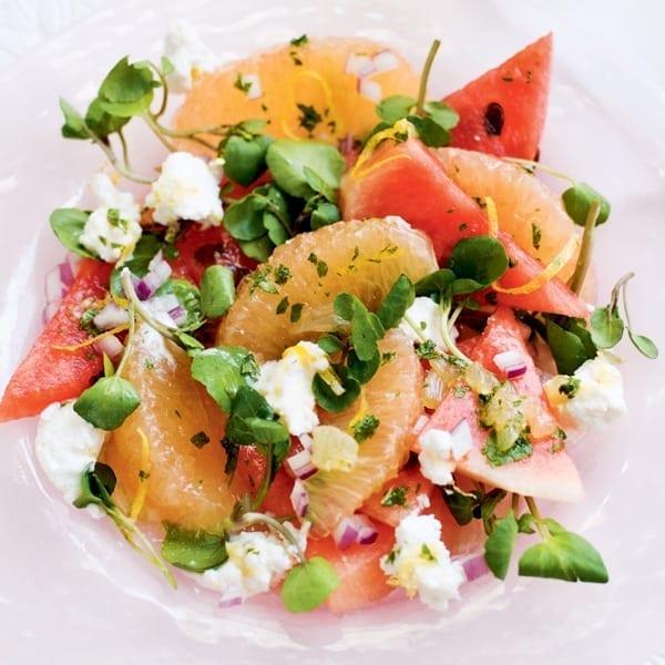 A bowl of Watermelon & Grapefruit Salad with Orange Segments at a summer gathering
