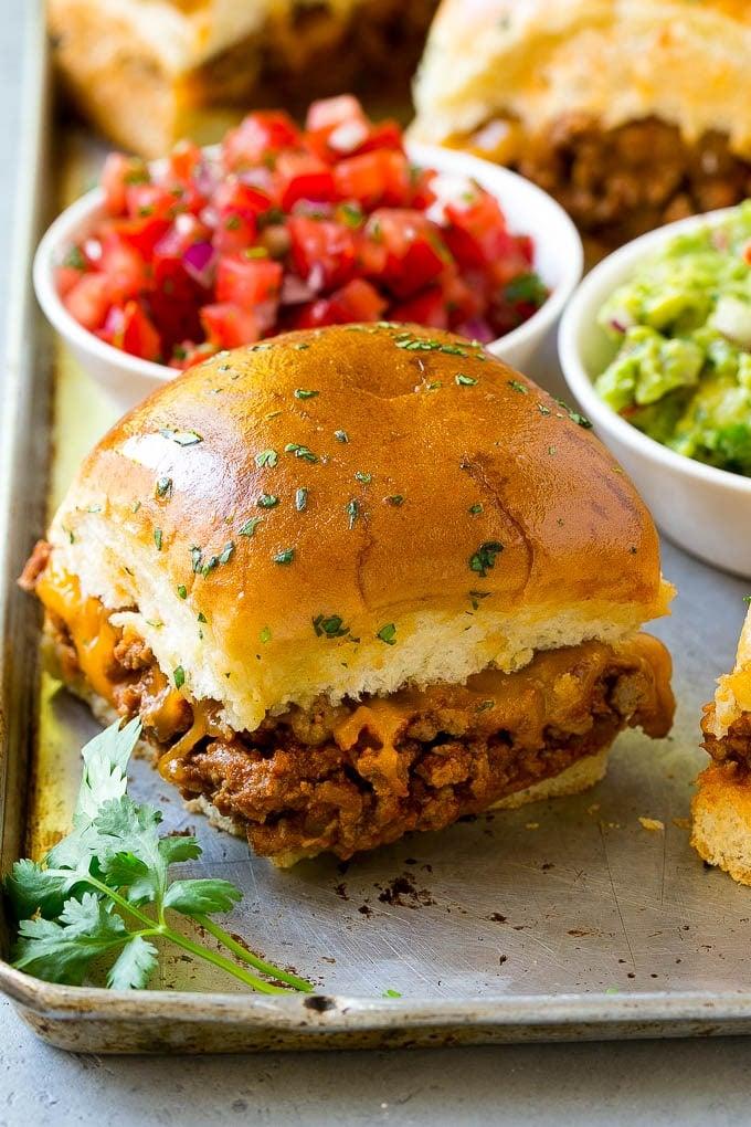 taco sliders topped with shredded lettuce and diced tomatoes