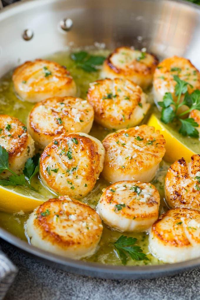 Close-up of perfectly pan-seared scallops with garlic butter sauce