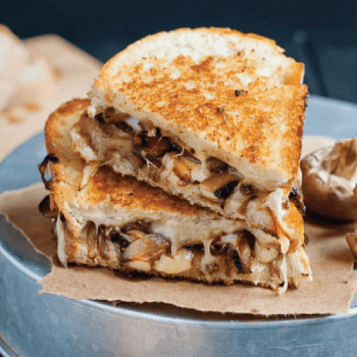 Slices of smoked Tilsit cheese next to fresh mushrooms