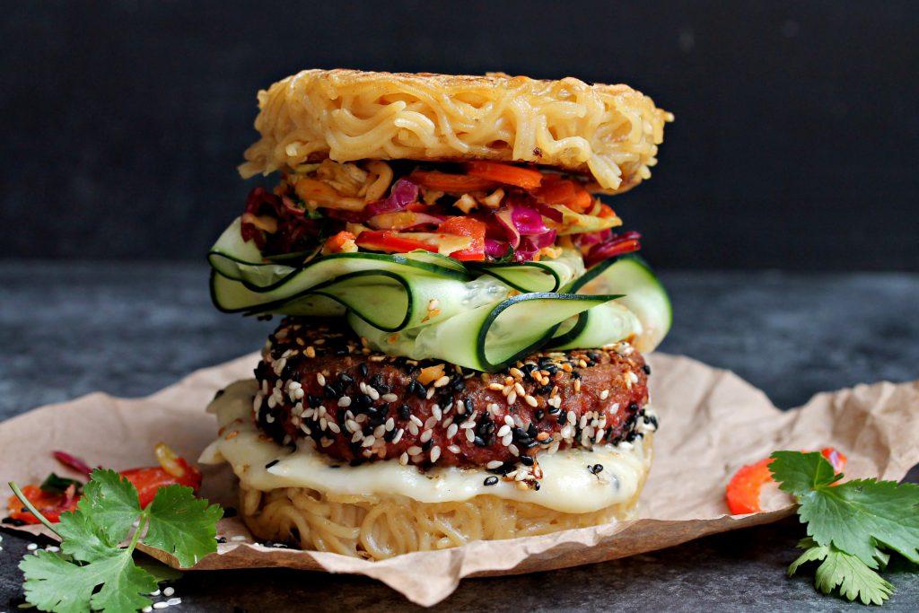 A vibrant image showcasing the finished ramen burger with pickled vegetables, garnished attractively