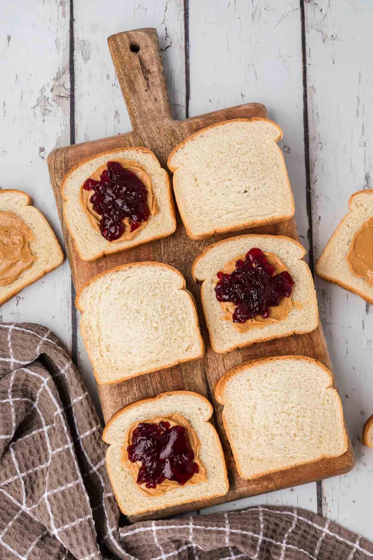 Various types of bread, peanut butter, and jams arranged on a table