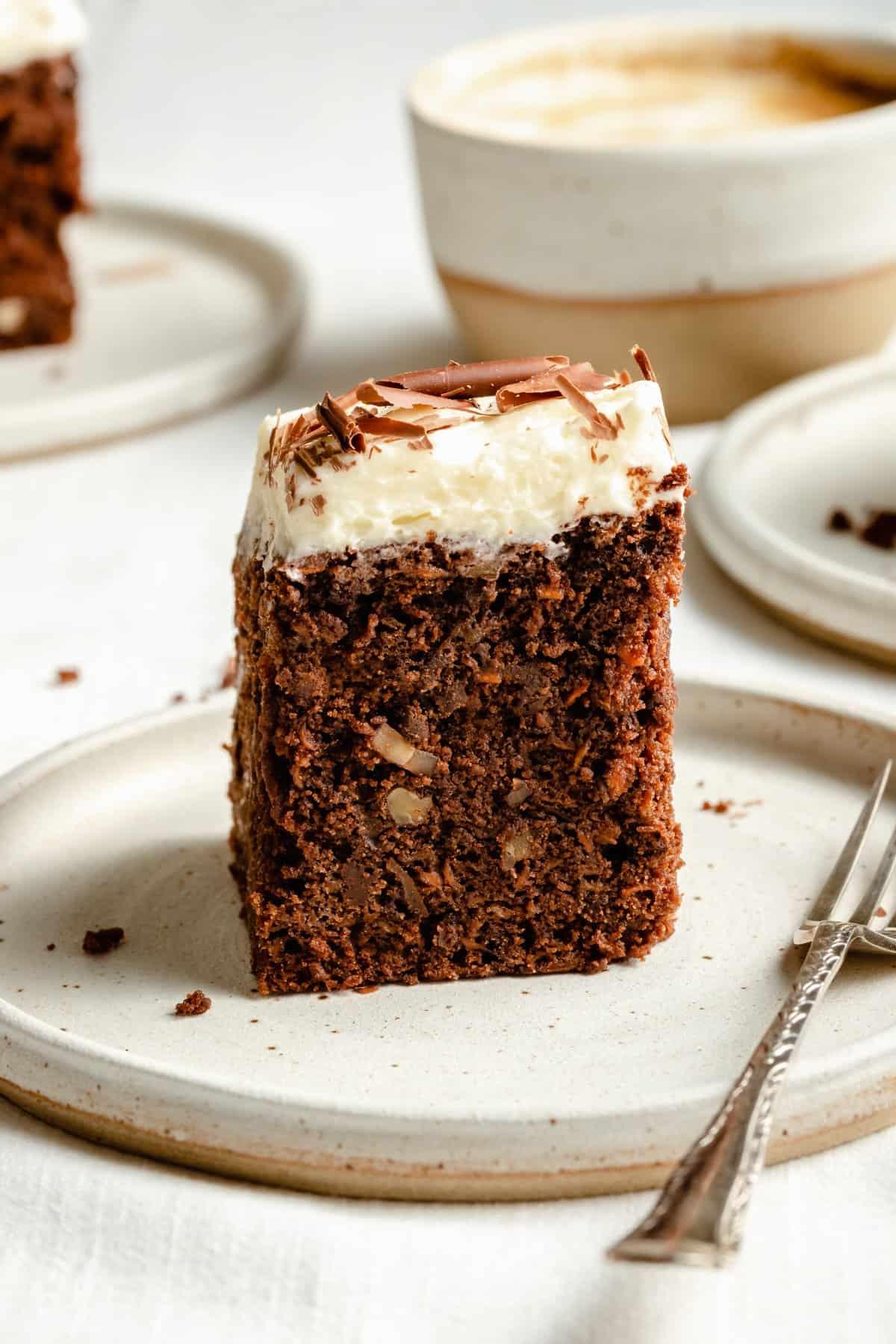 A plate of carrot cake brownies, perfectly frosted, with a fork nearby