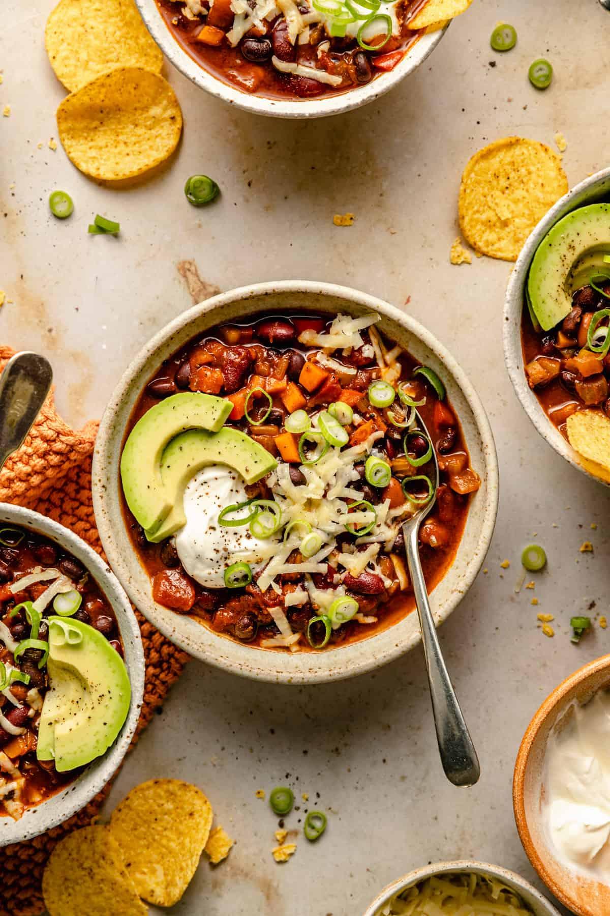 close up of a bowl of three bean and chorizo chili with toppings