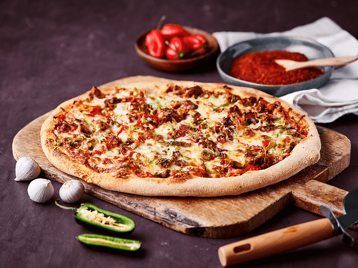 Spicy Beef Rendang Pizza with Chili, close-up shot showing the texture and ingredients