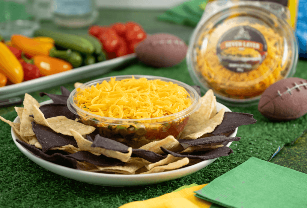 A bowl of zesty citrus dip being served with assorted fresh vegetables and crackers.