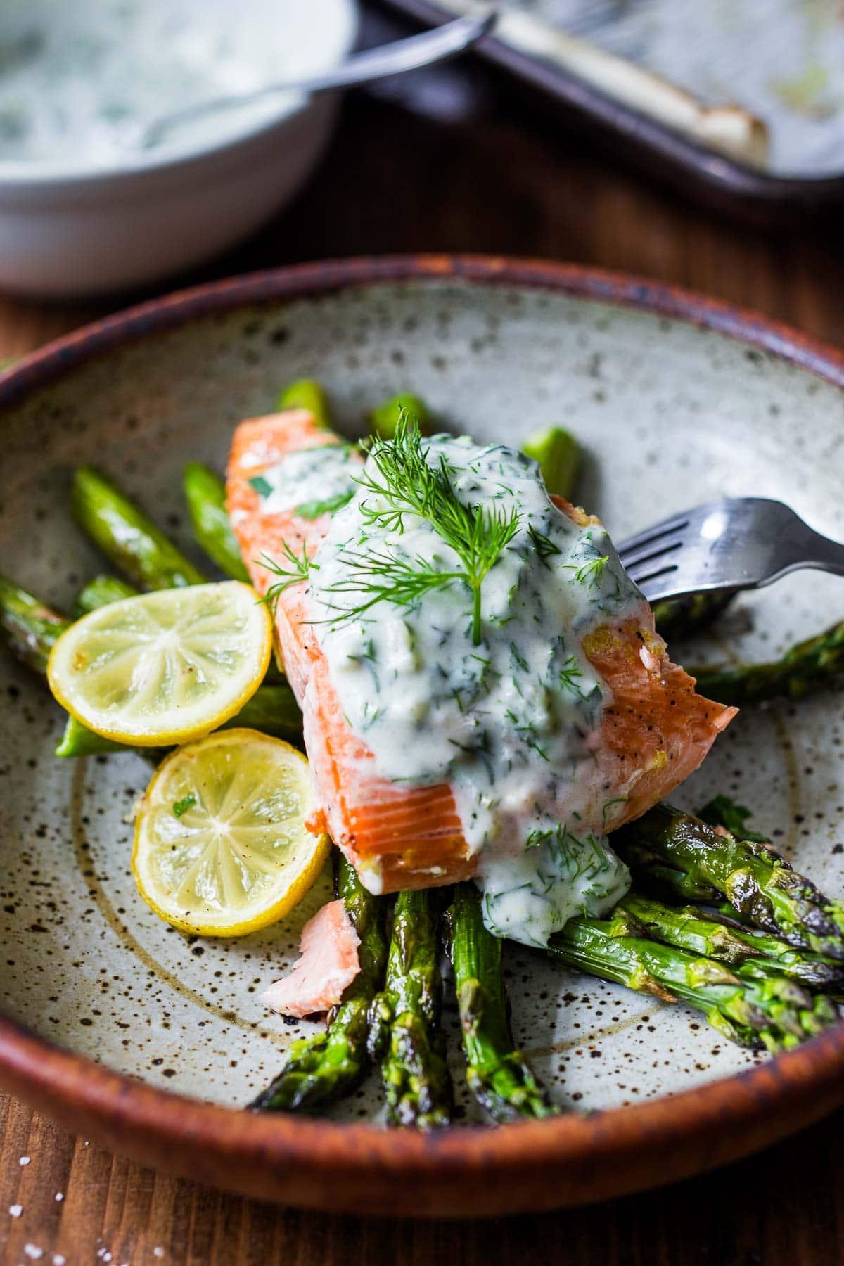 Grilled fish fillets with creamy dill sauce, garnished with fresh dill sprigs