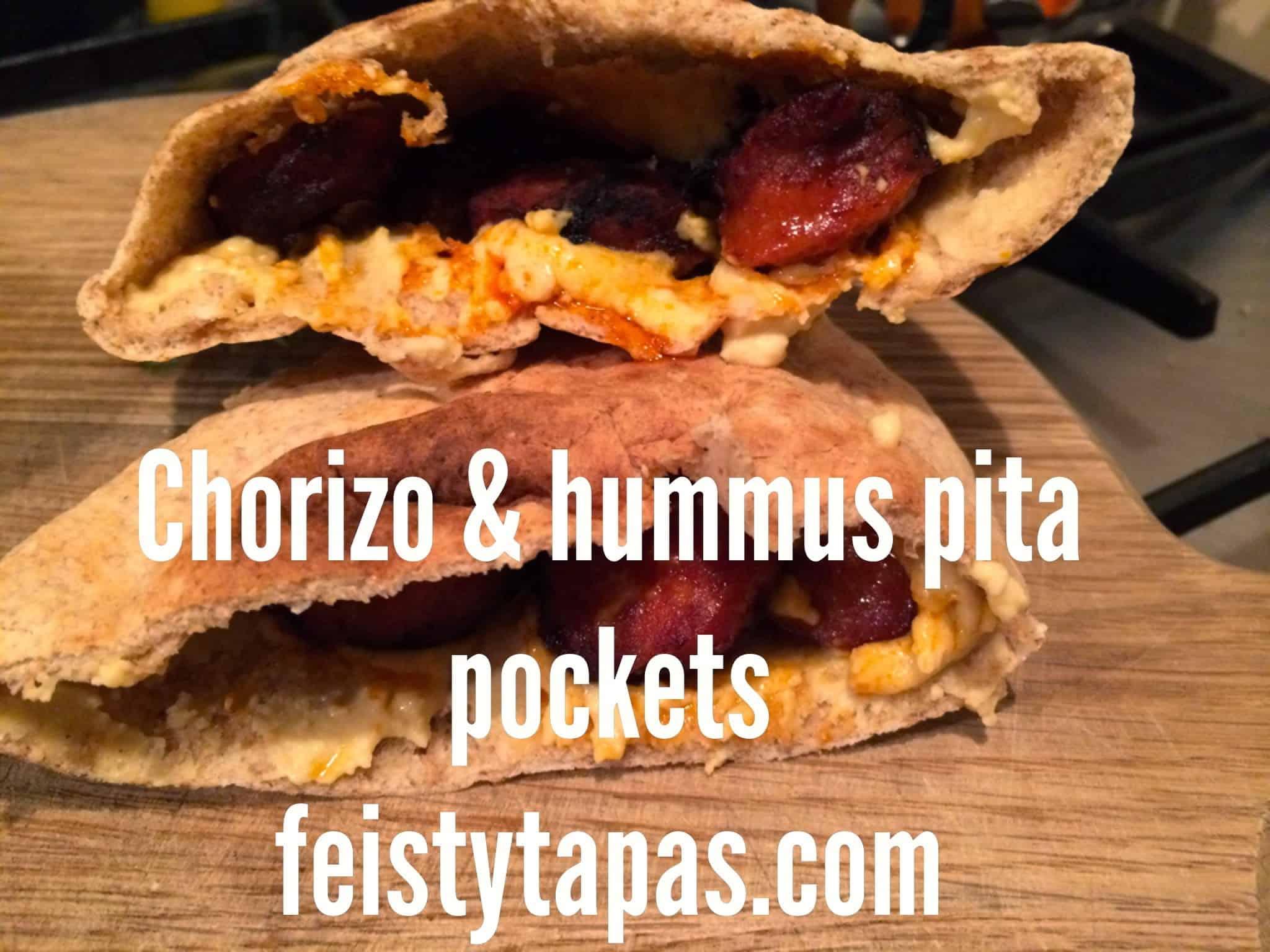A person spreading spicy chorizo and Manchego hummus on pita bread