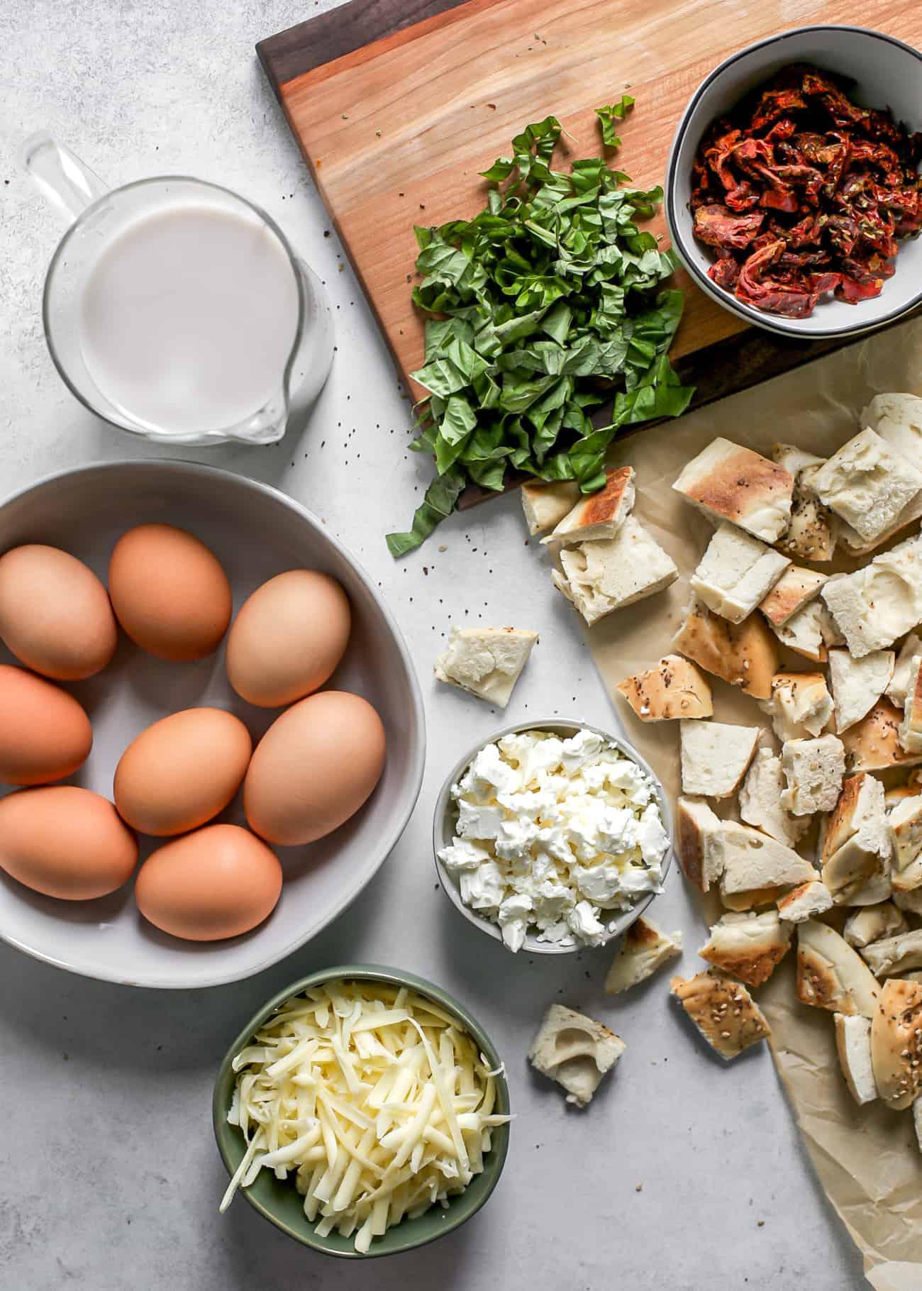 ingredients for breakfast bagel casserole laid out on a kitchen counter
