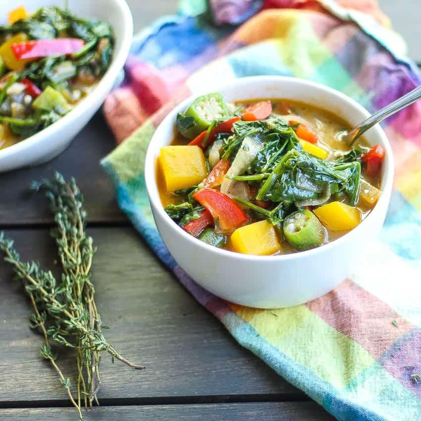 A person enjoying a bowl of Callaloo Gridlock in a tropical setting.
