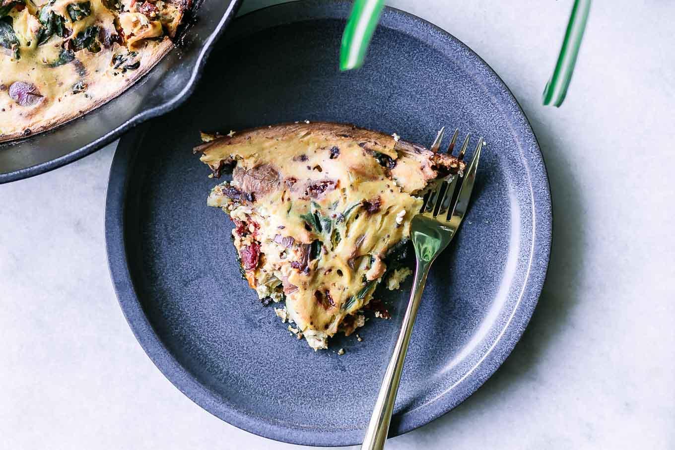 A person slicing a vegan frittata and serving it on a plate