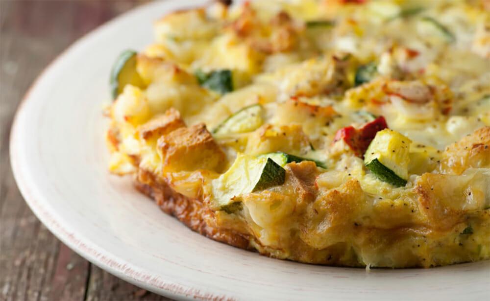 Close-up shot of a Lobster and Gruyere Frittata in a skillet, golden brown and bubbly