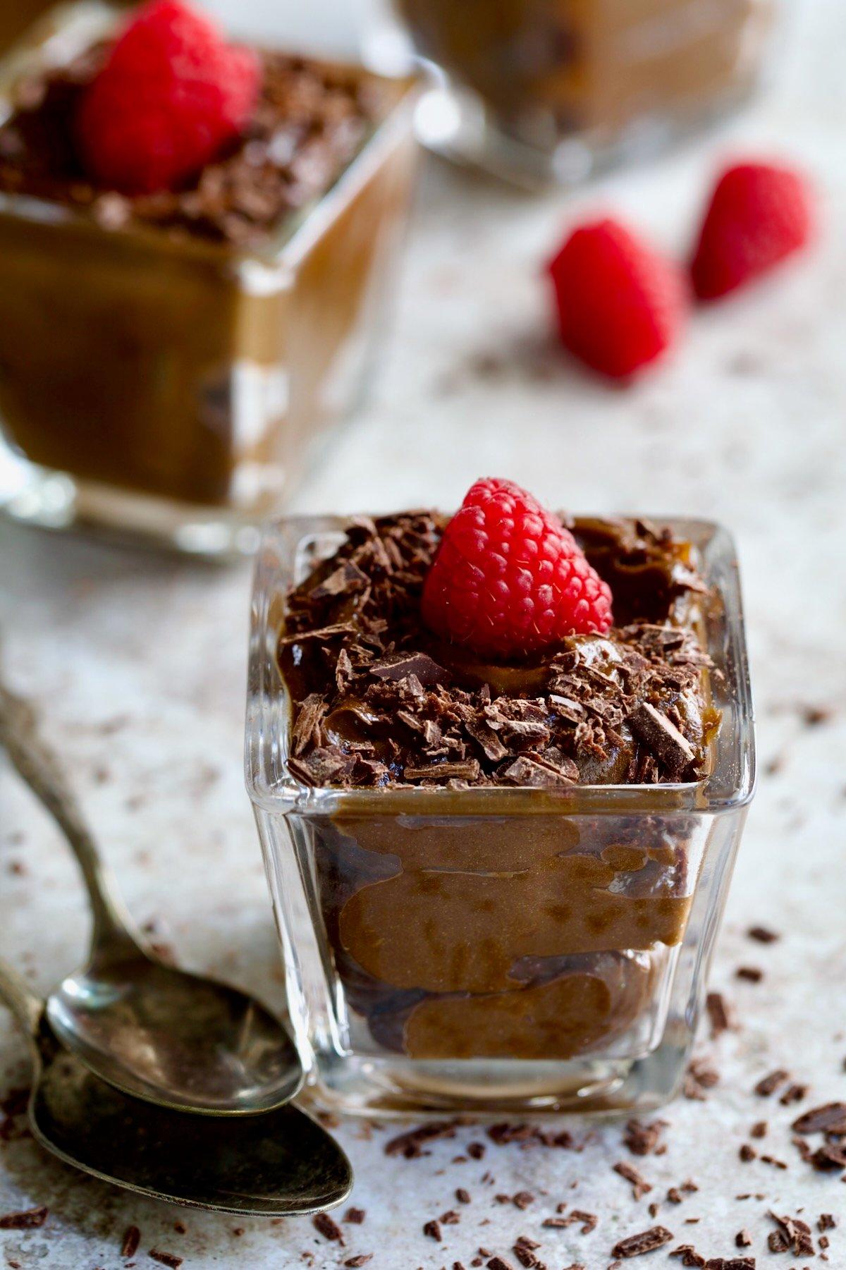 A bowl of chocolate avocado mousse garnished with salted caramel and chocolate shavings