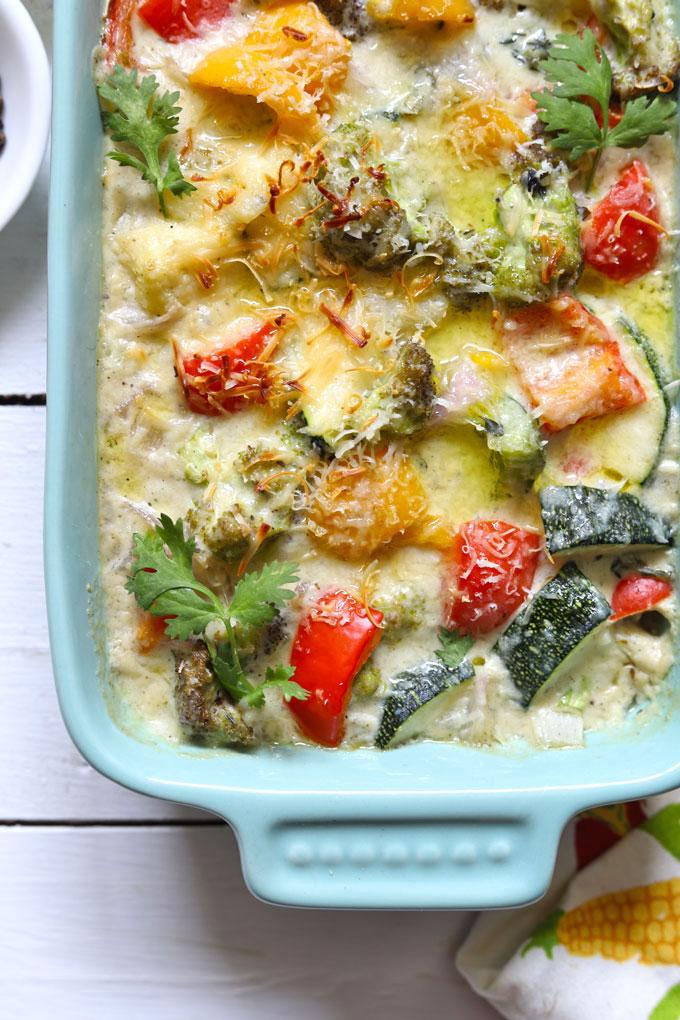 Close-up shot of layers of roasted vegetables and creamy béchamel in a baking dish