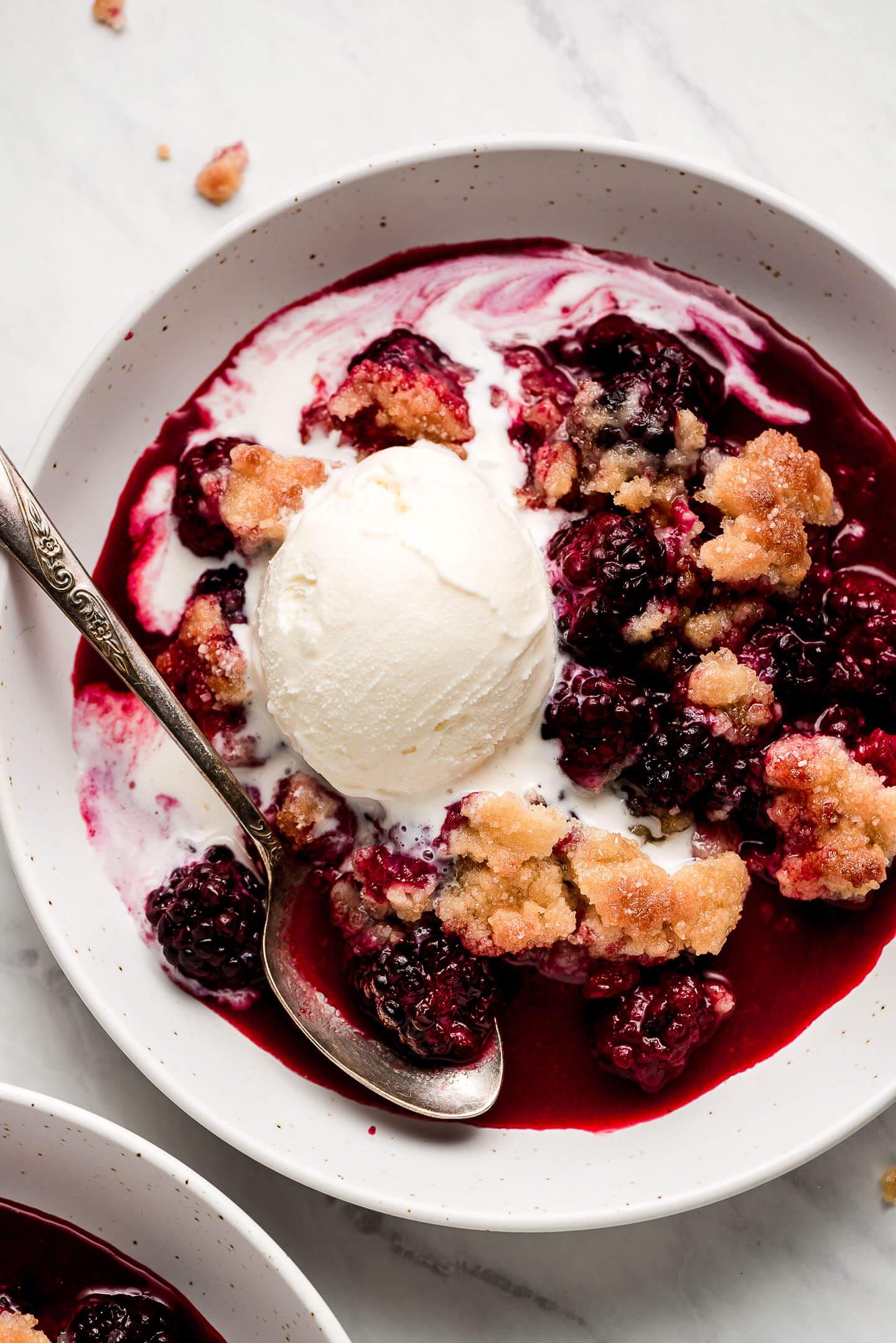 Close-up shot of warm blackberry cobbler with vanilla ice cream