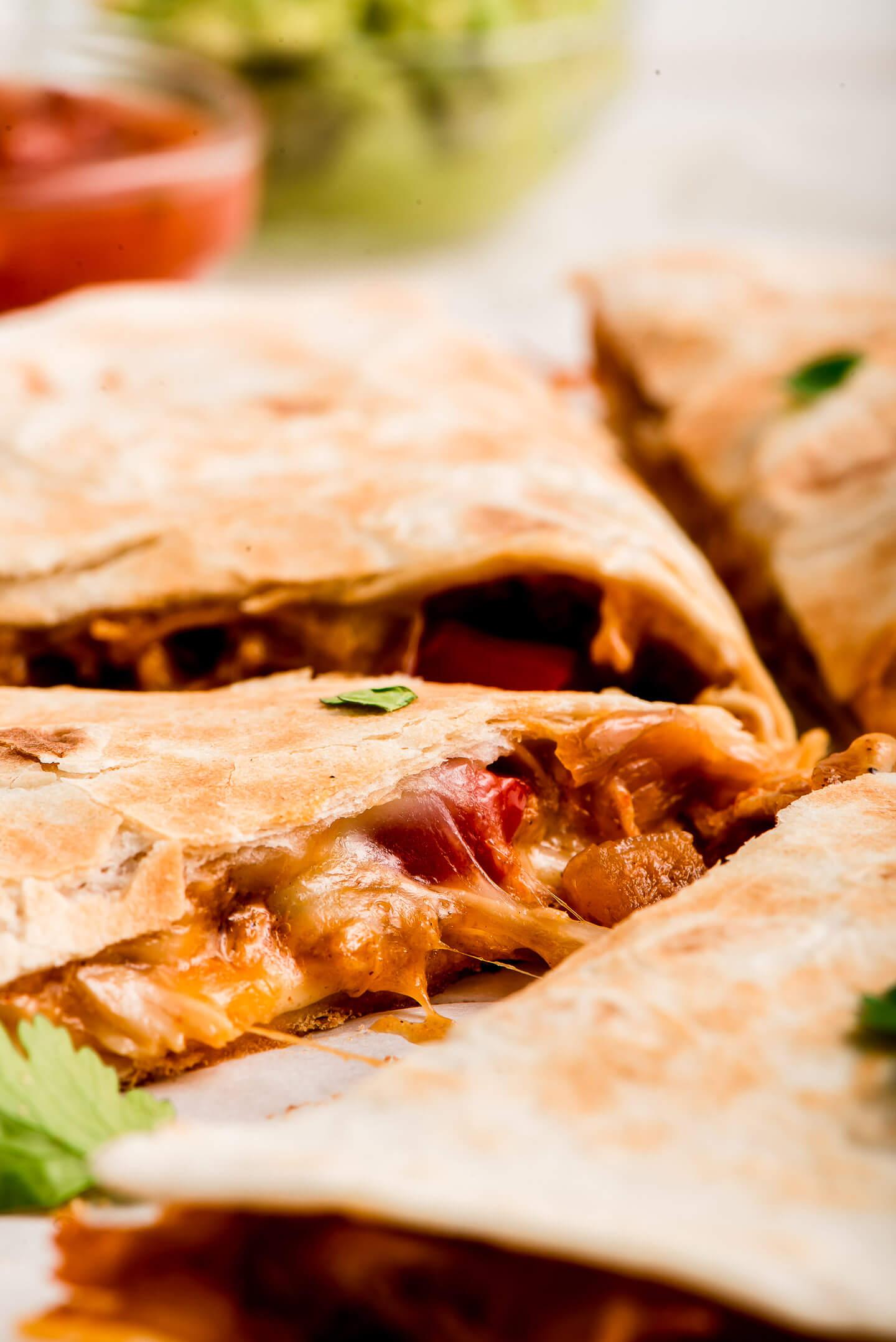 A close-up of the ingredients for chicken quesadillas: chicken, cheese, tortillas, salsa