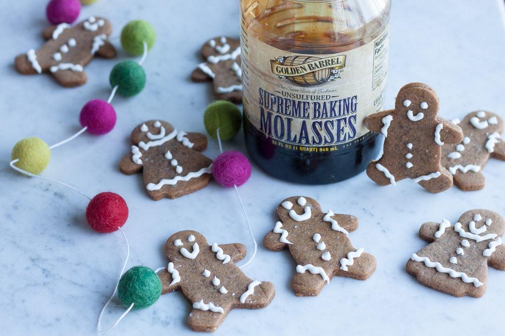Close-up shot of a single Molasses Midnight Gingerbread Man, intricately decorated with dark icing and silver sprinkles