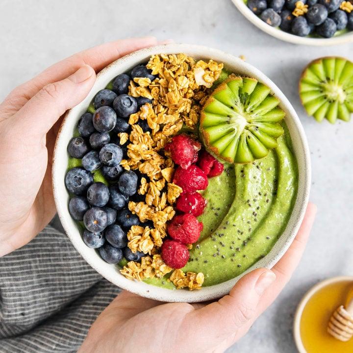Close up of a green smoothie bowl with various colorful toppings