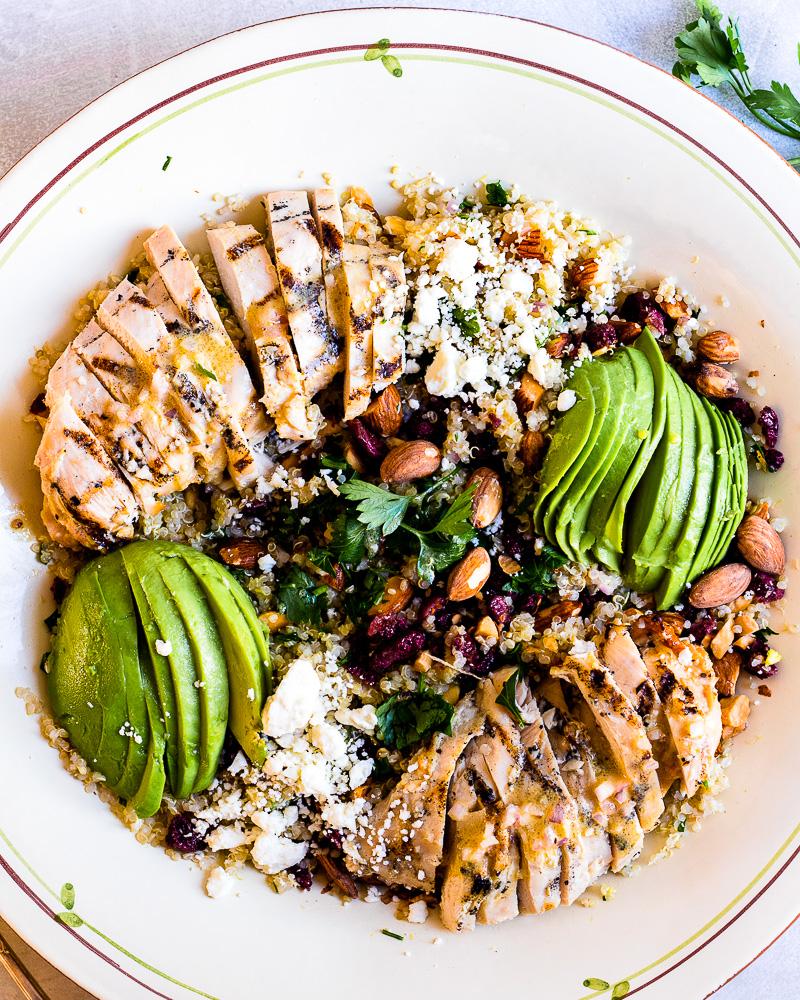 Close-up shot of a bowl of quinoa salad with grilled chicken and avocado