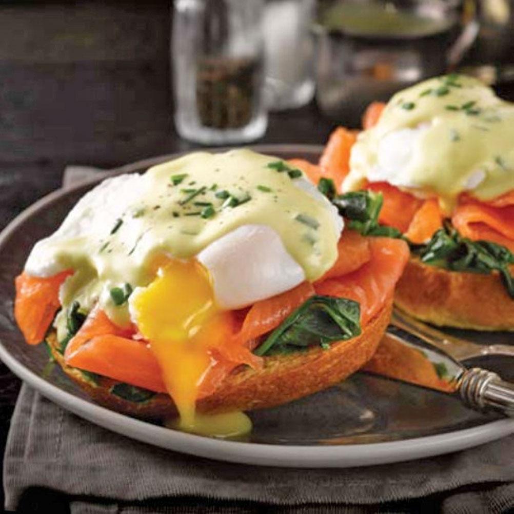 Close-up of a plate of eggs Benedict with smoked trout and horseradish
