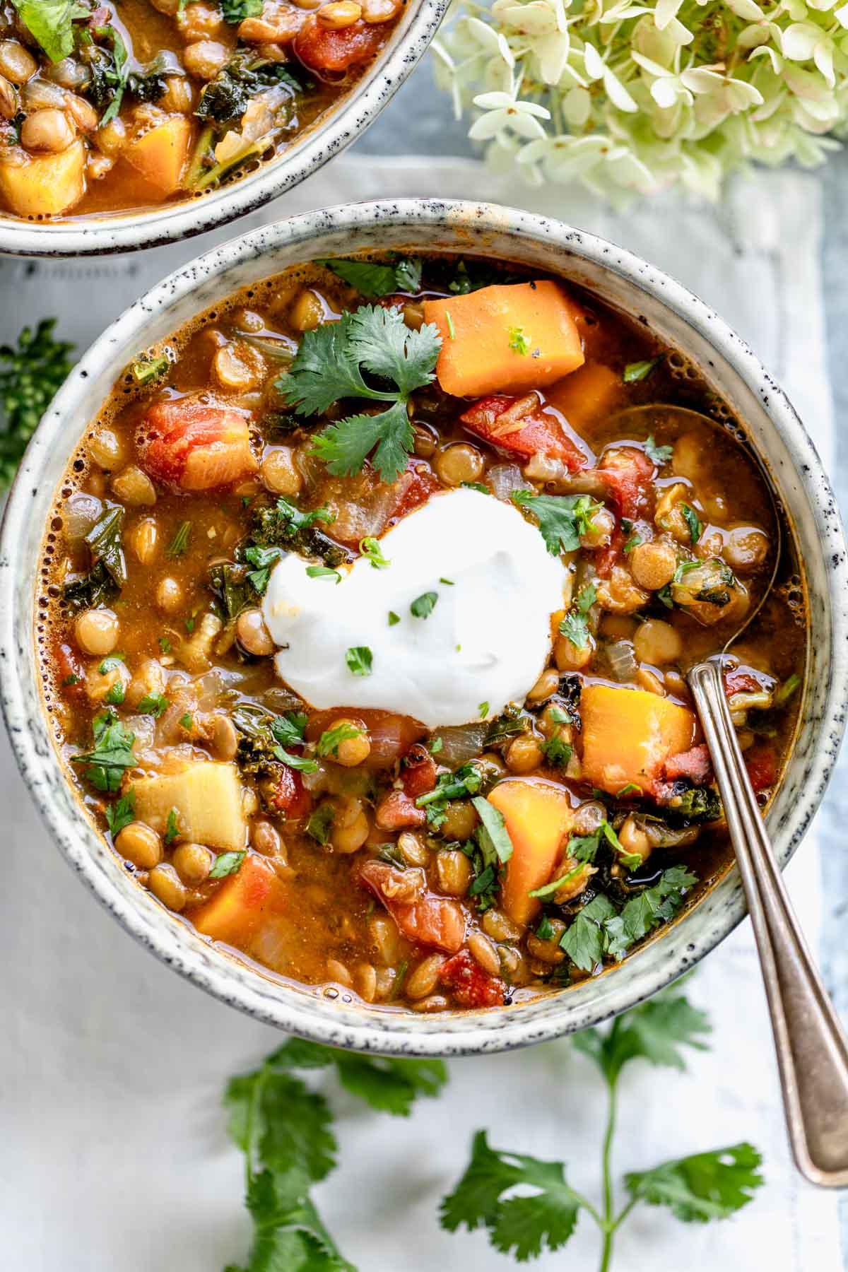 Close-up shot of a bowl of lentil soup with apples and cider