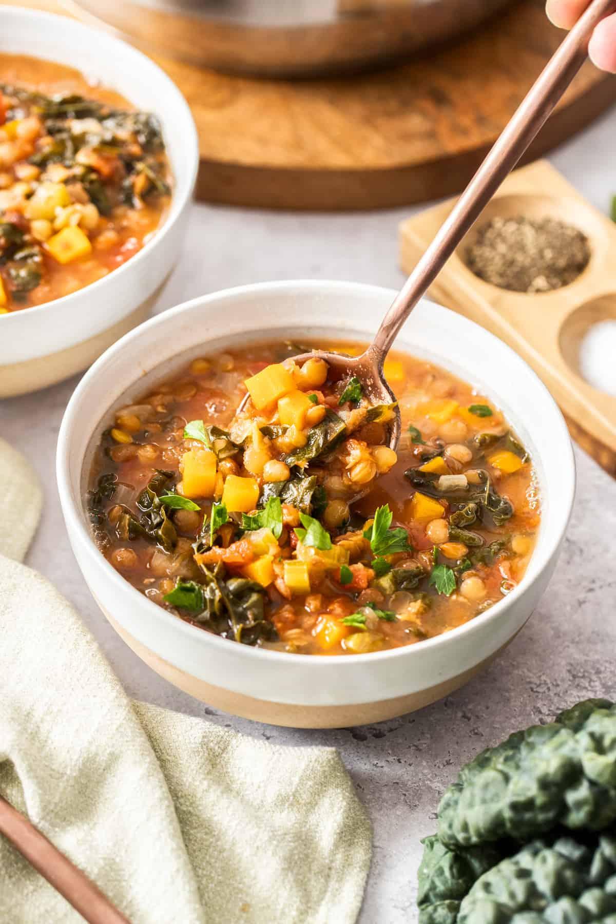 Person enjoying a bowl of black lentil soup after a hike