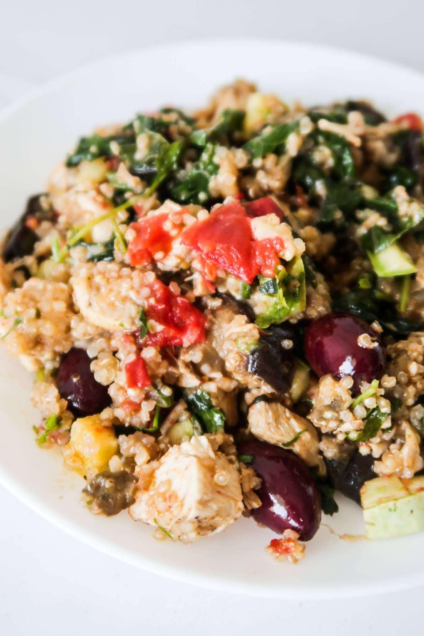a family enjoying a meal of roasted chicken with quinoa and kale around a dining table