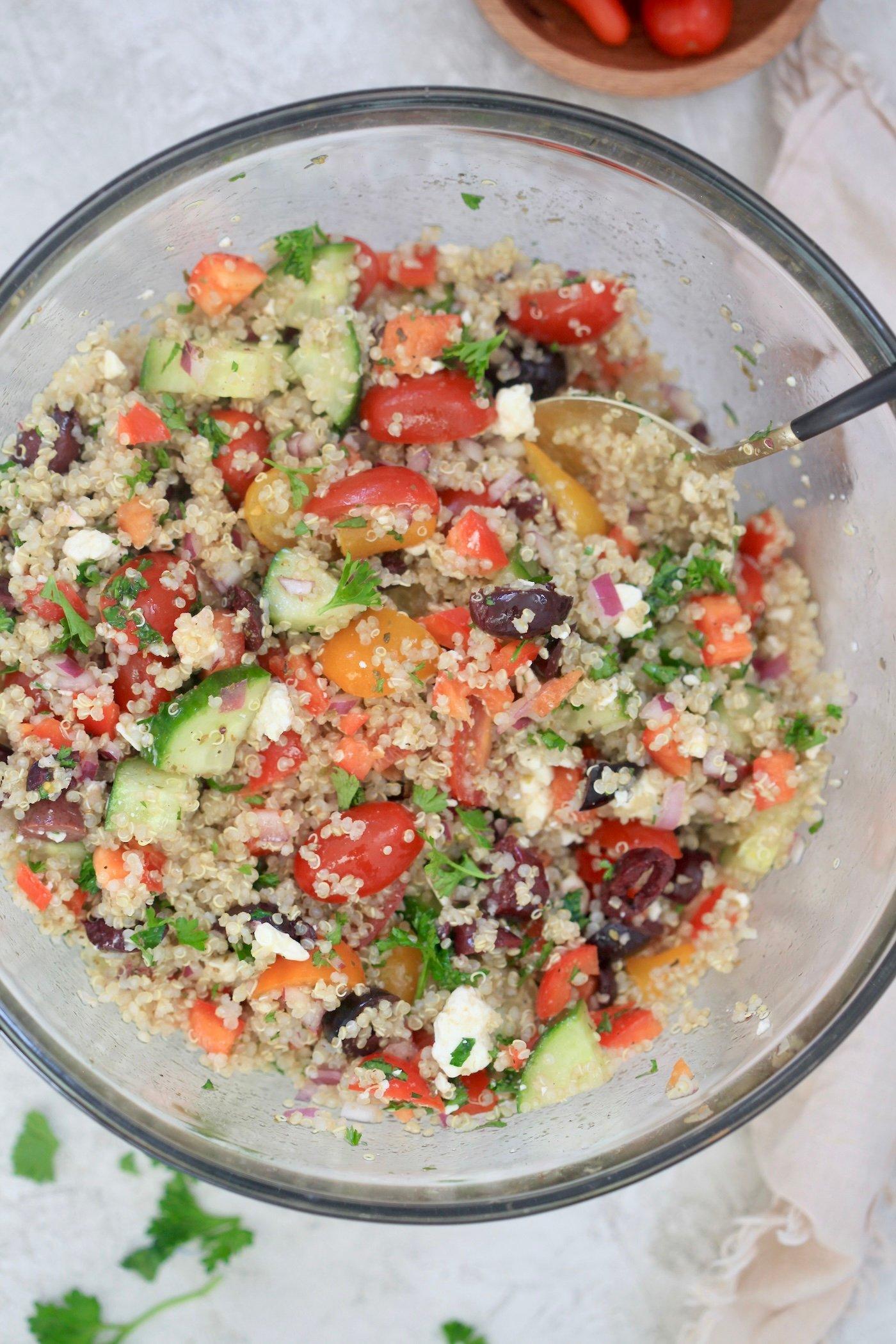 A vibrant and colorful bowl of Mediterranean Quinoa Salad with fresh herbs and vegetables.