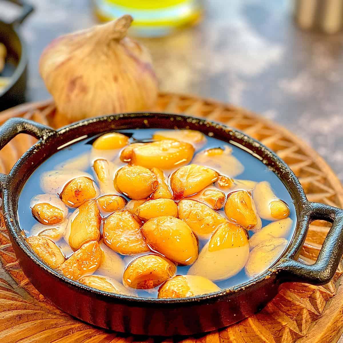 Close-up of roasted garlic cloves glistening with olive oil