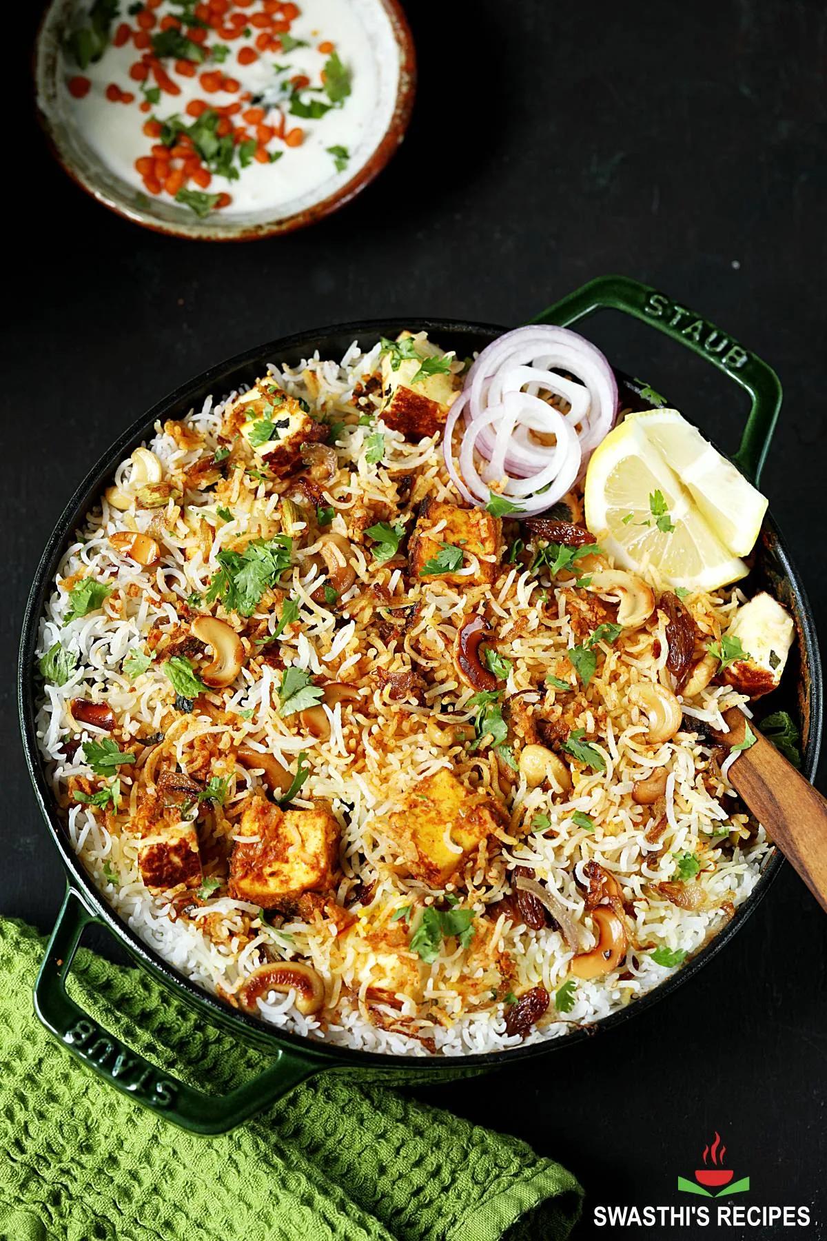A bowl of Mutter Paneer Biryani garnished with cilantro and fried onions