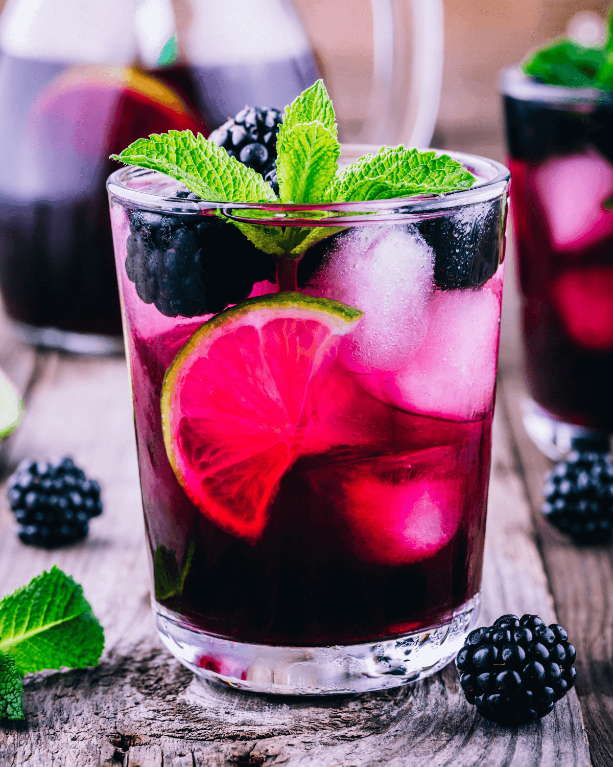 A Blackberry Burst Smoothie in a glass, garnished with fresh blackberries and mint.