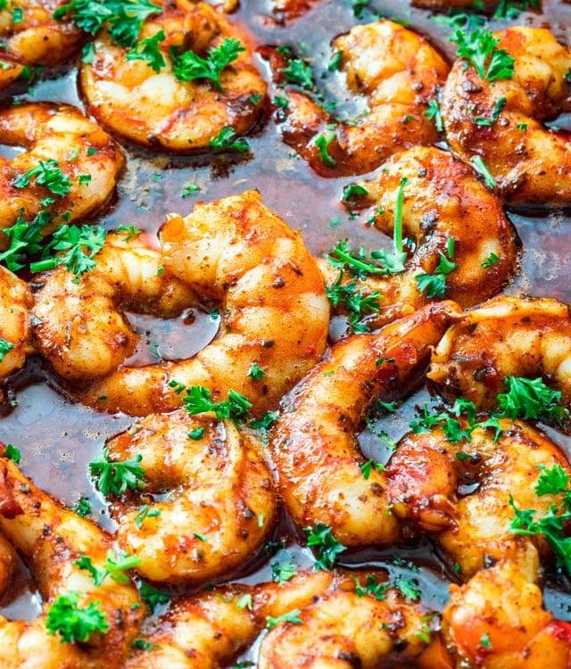 Close-up shot of raw shrimp being seasoned with spices