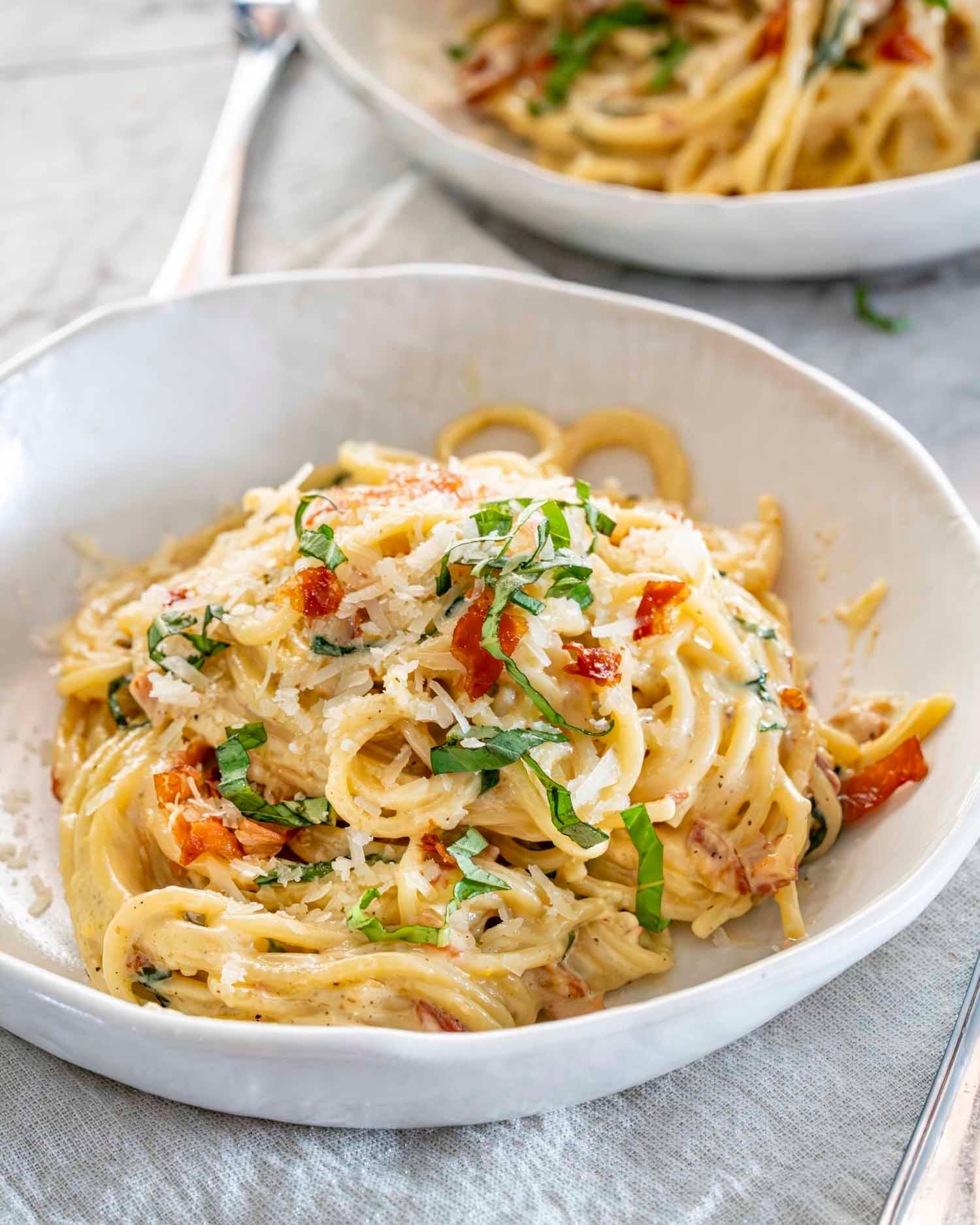 Person enjoying a bowl of creamy carbonara pasta