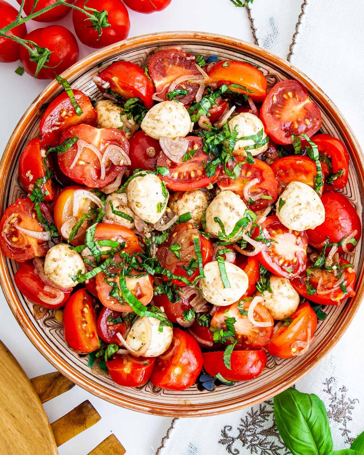 Creamy tomato and basil salad in a rustic bowl, garnished with fresh basil leaves