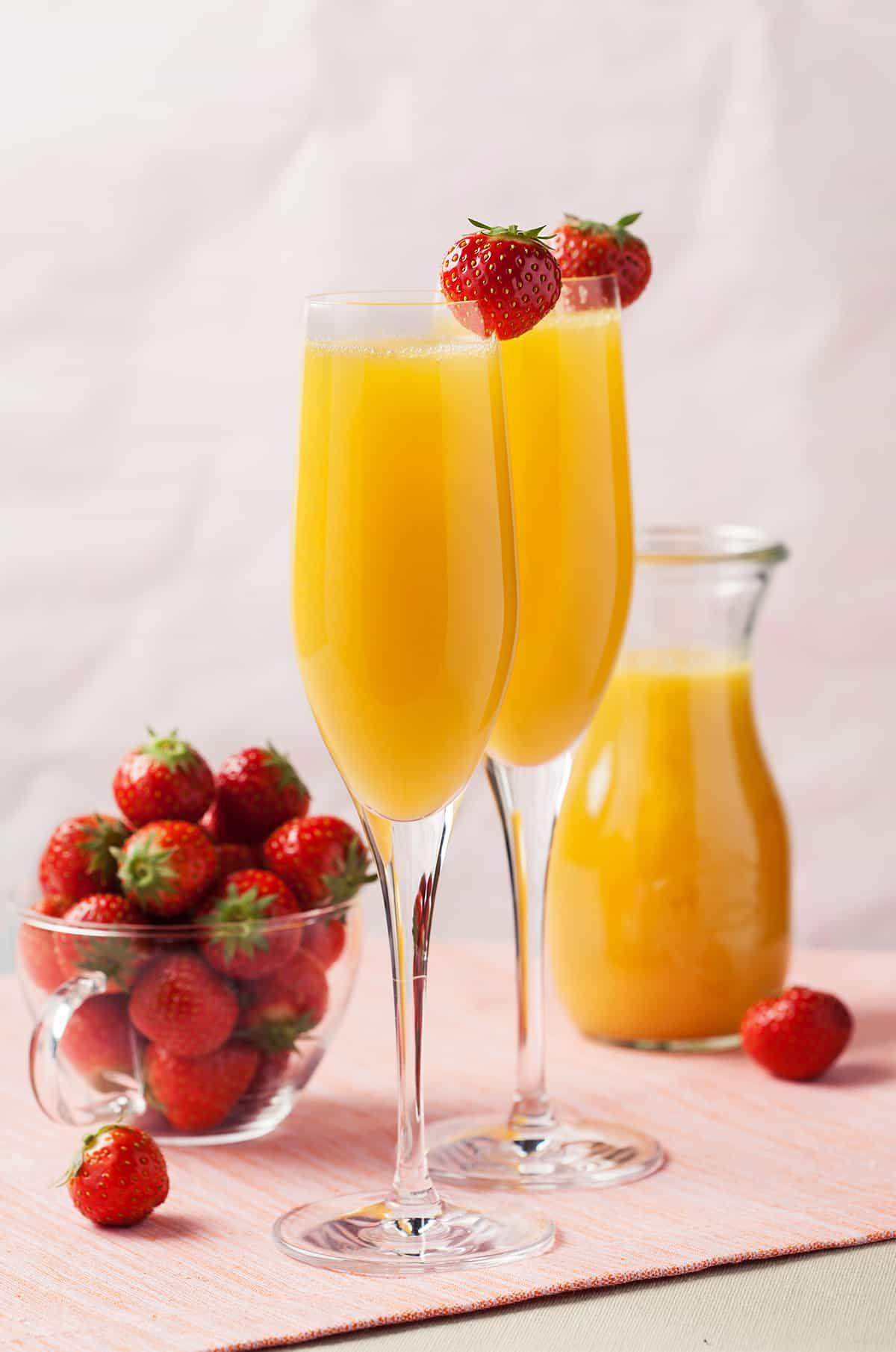 elegant champagne flutes filled with a cava mimosa, garnished with orange slices
