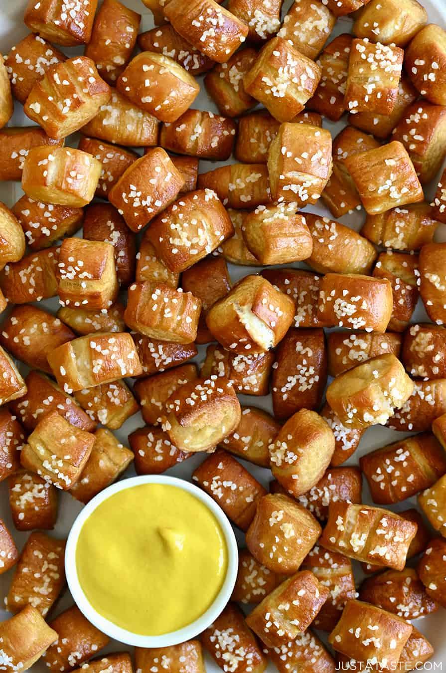 Close-up shot of golden-brown beer pretzel bites with a side of peanut sauce