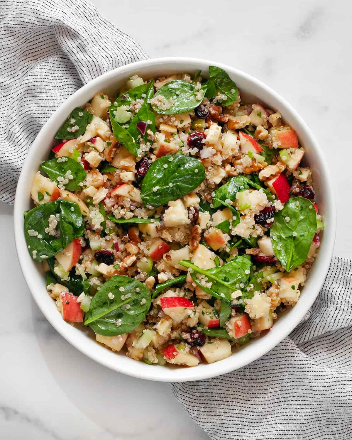 close up shot of harvest quinoa salad with apples and walnuts in a bowl