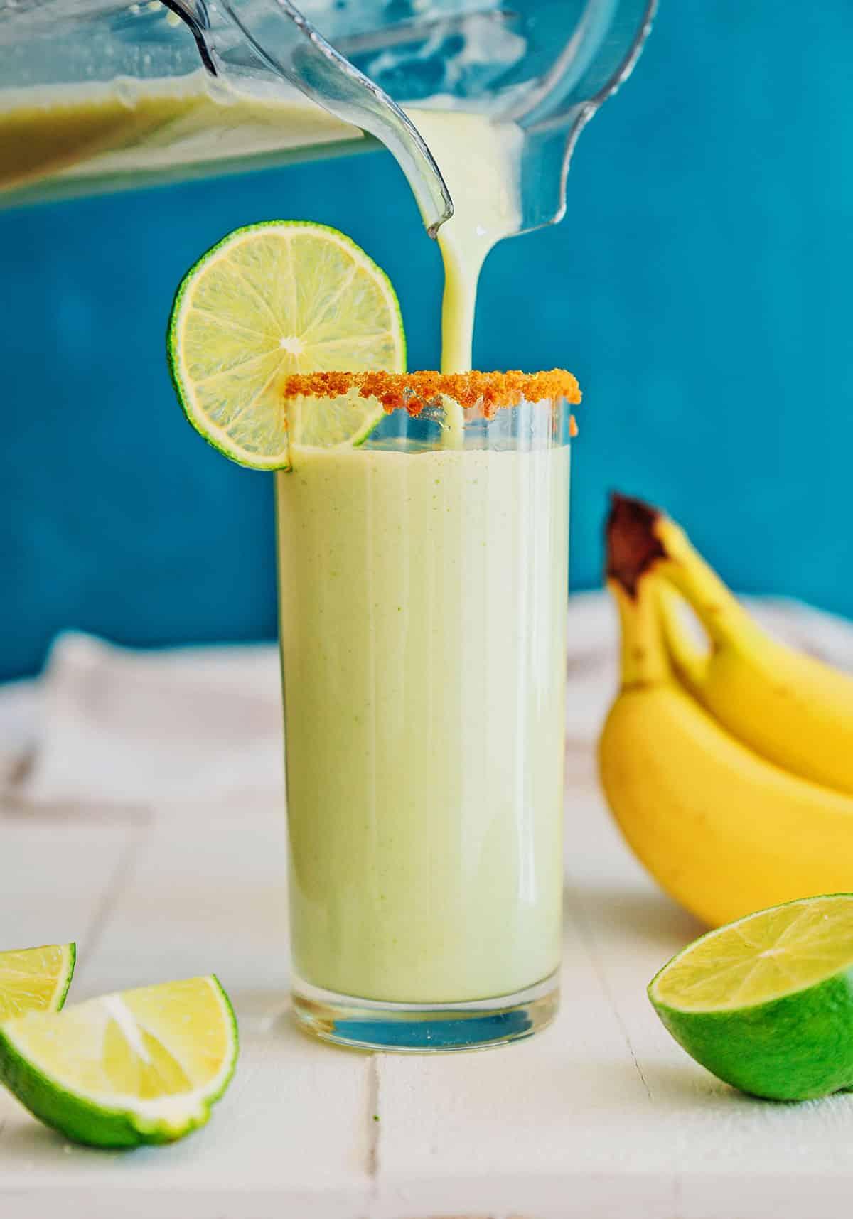 A person enjoying a key lime pie smoothie outdoors on a sunny day