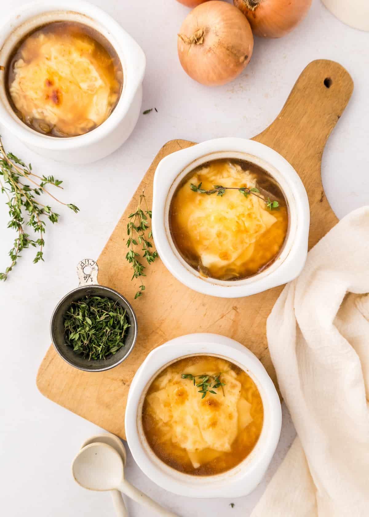 Overhead shot of several bowls of keto French onion soup around a dining table
