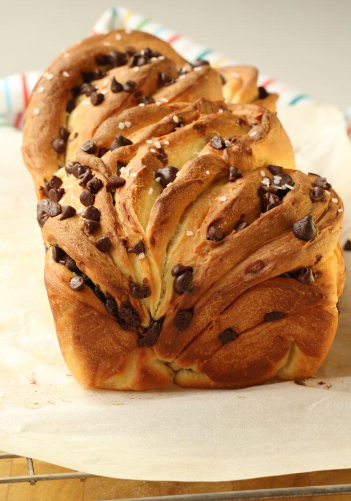 A person enjoying a slice of brioche with chocolate chips
