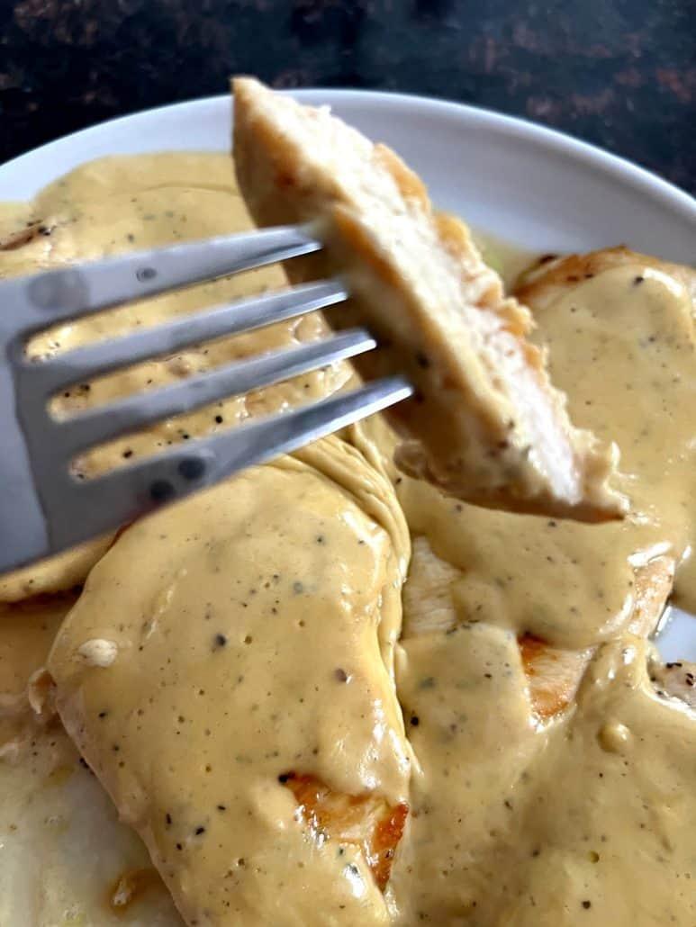 A close-up of the creamy mustard gravy, showing its texture and smooth consistency.