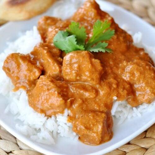 Close-up shot of a bowl of butter chicken and pulao