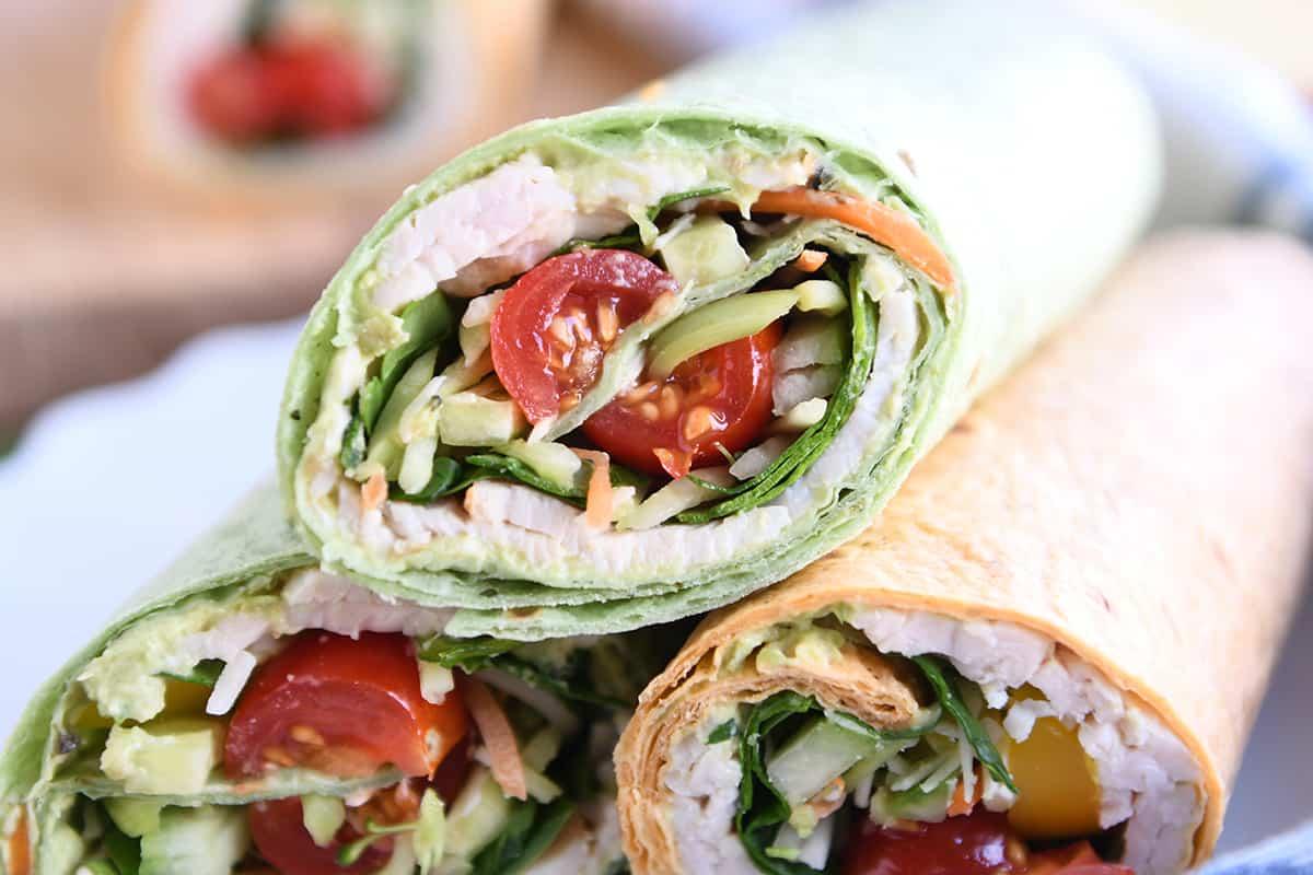 Person happily eating a turkey and avocado wrap