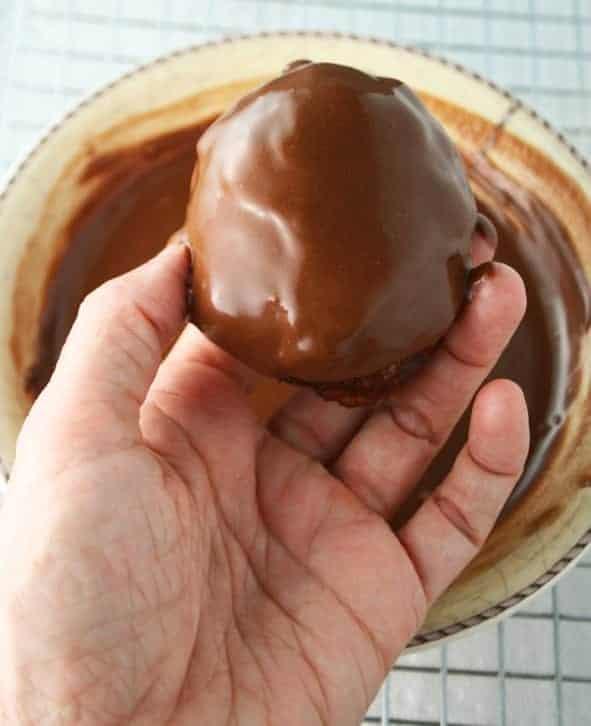 German chocolate donut being dipped in chocolate glaze
