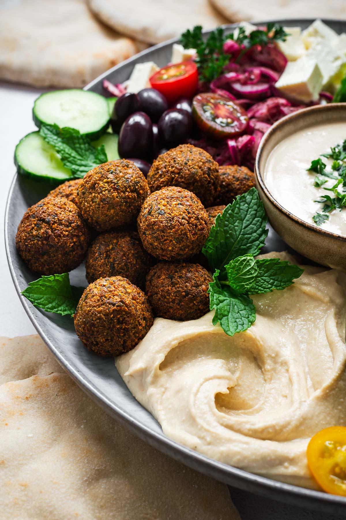 Nori falafel plated with tahini sauce and fresh herbs