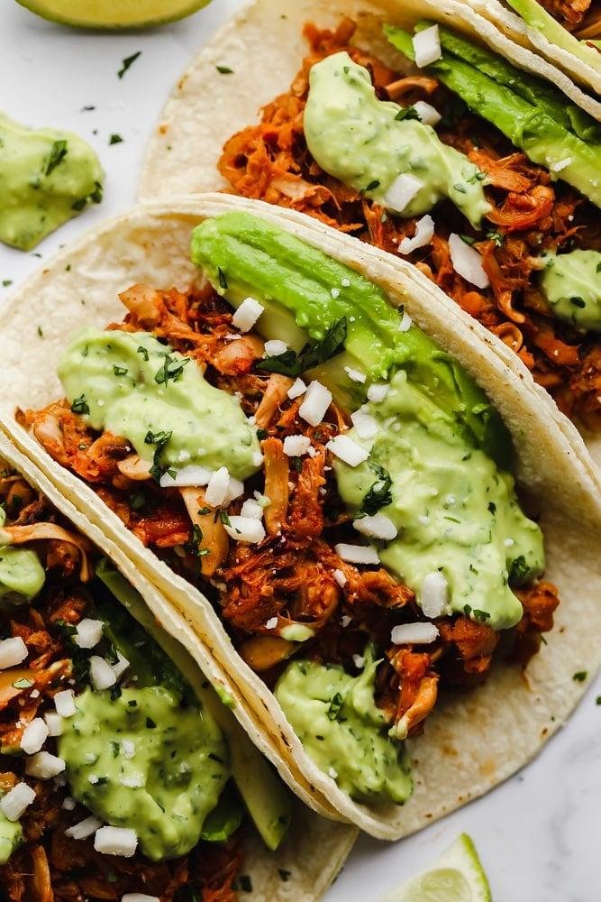Close-up shot of jackfruit tacos with vibrant watermelon salsa, garnished with cilantro and lime