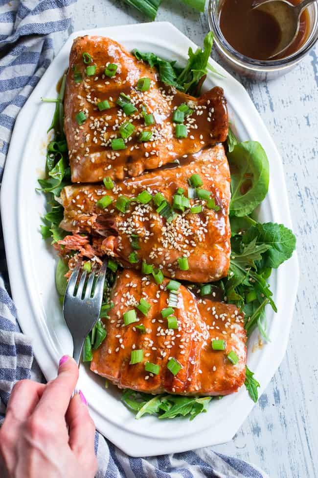 Grilled Paleo Salmon with glossy teriyaki glaze, garnished with sesame seeds and green onions